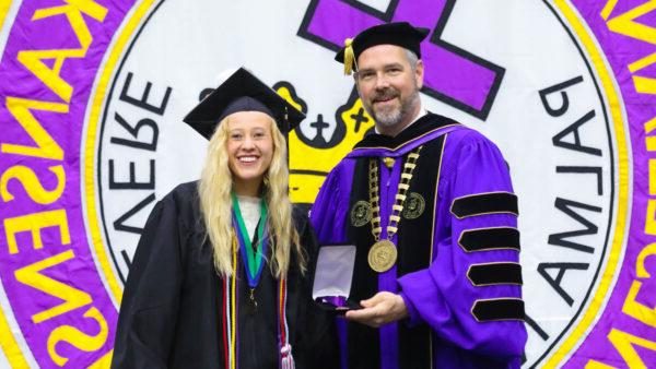 KWU student with president at graduation